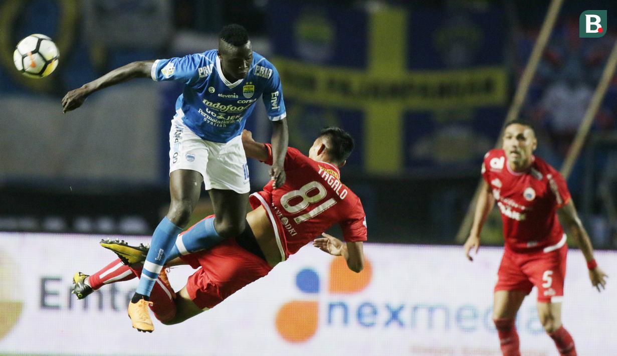 Striker Persib Bandung, Ezechiel N'douassel, duel udara dengan bek Persija Jakarta, Vava Yagalo, pada laga Liga 1 di Stadion GBLA, Jawa Barat, Minggu (23/9/2018). Persib menang 3-2 atas Persija. (Bola.com/M Iqbal Ichsan)