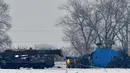 Petugas penegak hukum memeriksa helikopter militer Kirgistan Mi-8-MTV setelah jatuh di pinggiran Bishkek pada 17 Januari 2024. (VYACHESLAV OSELEDKO/AFP)