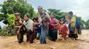 Warga berjalan melintasi banjir di Pyinmana di wilayah Naypyidaw, Myanmar, pada tanggal 13 September 2024. (Sai Aung MAIN/AFP)