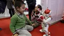 Robot bernama "Nao" buatan Aldebaran Robotics beraksi dengan berdansa selama acara Konferensi Robot Dunia di Beijing, Cina,  (24/11). Selain pameran robot, Acara ini juga mengadakan kontes robot bagi para pelajar dan pemuda. (REUTERS/Jason Lee)