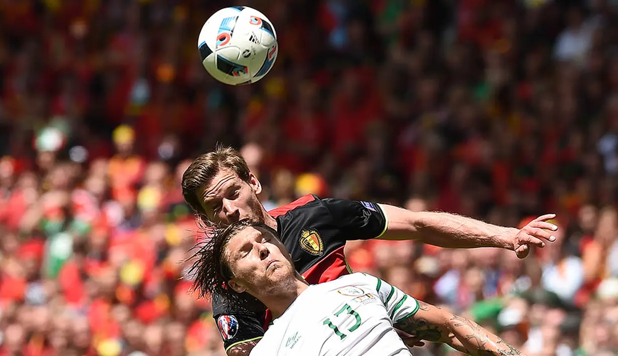 Bek Belgia, Jan Vertonghen, duel udara dengan gelandang Irlandia, Jeffrey Hendrick, pada laga Grup E Piala Eropa 2016. Kemenangan ini membuat peluang Belgia lolos ke 16 besar kembali terbuka. (AFP/Nicolas Tucat)