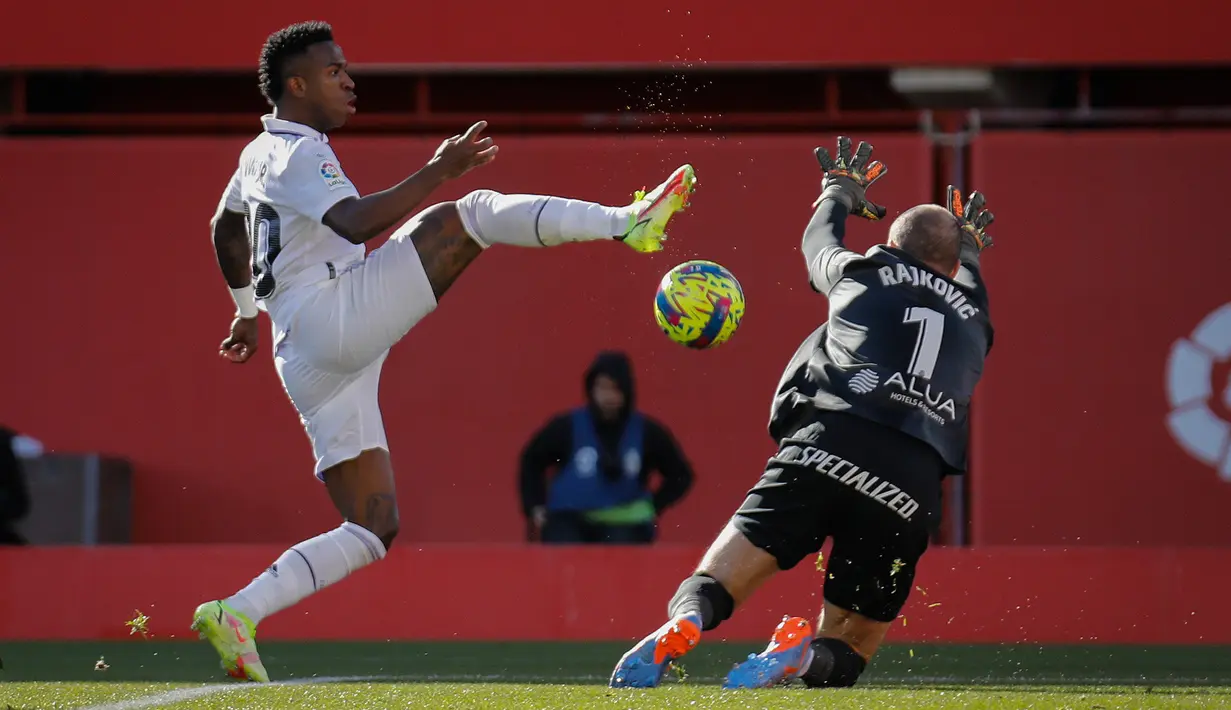 Pemain Real Madrid, Vinicius Junior berusaha melewati hadangan penjaga gawang Real Mallorca Predrag Rajkovic dalam pertandingan pekan ke-20 La Liga 2022/2023 yang berlangsung di Palma de Mallorca, Minggu (5/2/2023). (AP Photo/Francisco Ubilla)