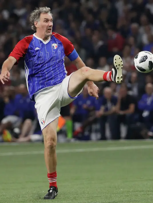 Bek Laurent Blanc berusaha mengontrol bola saat pertandingan tim Prancis 98 dengan tim FIFA 98 di Arena U, Nanterre, Paris (12/6). Pertandingan ini memperingati 20 tahun kemenangan Prancis di Piala Dunia 1998. (AFP Photo/Thomas Samson)