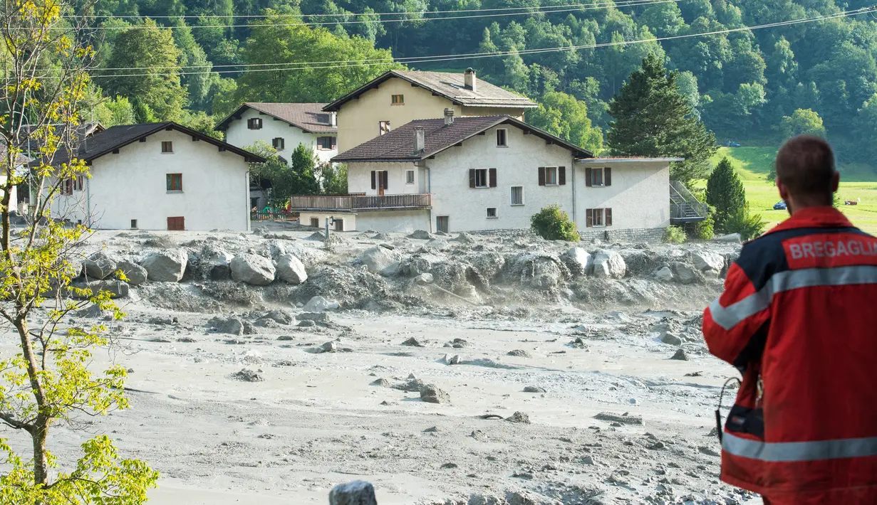 Seorang pria berada di lokasi tanah longsor yang menerjang desa Bondo di Swiss selatan (23/8). Polisi mengatakan akibat bencana tersebut delapan orang hilang. (Giancarlo Cattaneo / Keystone via AP)