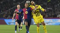 Pemain depan Barcelona asal Brasil #11, Raphinha, dan gelandang Borussia Dortmund asal Jerman #23, Emre Can (Kanan), berebut sundulan kepala selama pertandingan leg pertama perempat final Liga Champions UEFA antara FC Barcelona dan BVB Borussia Dortmund di Estadi Olimpic Lluis Companys di Barcelona, Kamis dini hari WIB (10-4-2025). (Josep LAGO/AFP)