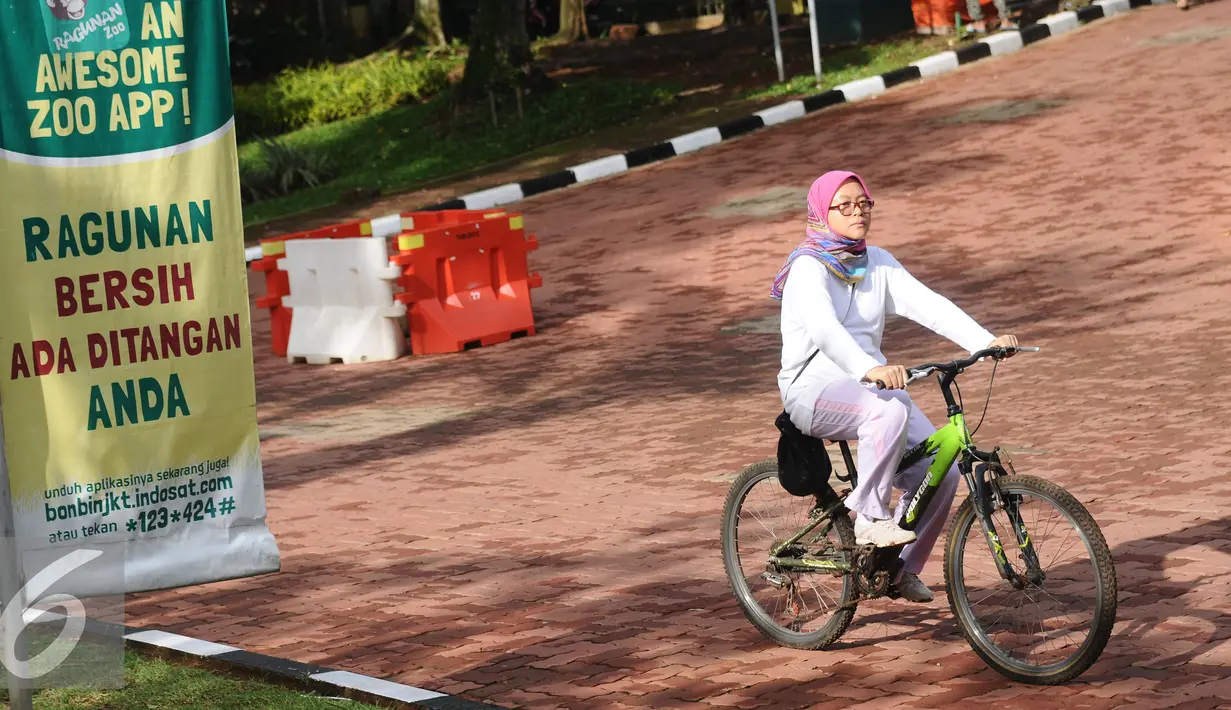 Warga bersepeda melintas di salah satu bundaran di kawasan Kebun Binatang Ragunan, Jakarta, Minggu (9/10). Kawasan KBR menjadi salah satu lokasi alternatif warga Jakarta untuk berolahraga pada Minggu pagi. (Liputan6.com/Helmi Fithriansyah)