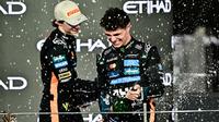 Juara dunia dan pembalap McLaren peringkat ketiga, Lando Norris (kanan), merayakan kemenangan bersama rekan setimnya, pembalap Australia peringkat kedua, Oscar Piastri, di podium pada akhir Grand Prix Formula Satu Abu Dhabi di Sirkuit Yas Marina, Abu Dhabi, pada 7 Desember 2025.
(Giuseppe CACACE/AFP)