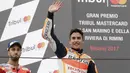 Marc Marquez (kanan) melambaikan tangan kepada fans usai menang pada  balapan MotoGP San Mariono di Sikuit Marco Simoncelli, Misano Adriatico, Italia (10/9/2017). (AP/Antonio Calanni)