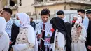 Suasana haru dan bahagia terlihat ketika para pasangan berjalan bersama di tengah sorakan dan tepuk tangan warga yang merayakan momen istimewa itu. Tampak dalam foto, para pengantin Palestina berkumpul selama perayaan pernikahan massal untuk para pengantin Palestina yang diselenggarakan oleh Yayasan Bantuan Kemanusiaan Turki (IHH) di Kota Gaza pada 11 Mei 2026. (Omar AL-QATTAA/AFP)