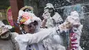 Orang-orang bermain dengan busa selama Karnaval Kulit Hitam dan Kulit Putih di Pasto, Kolombia pada tanggal 3 Januari 2024. (JOAQUIN SARMIENTO/AFP)