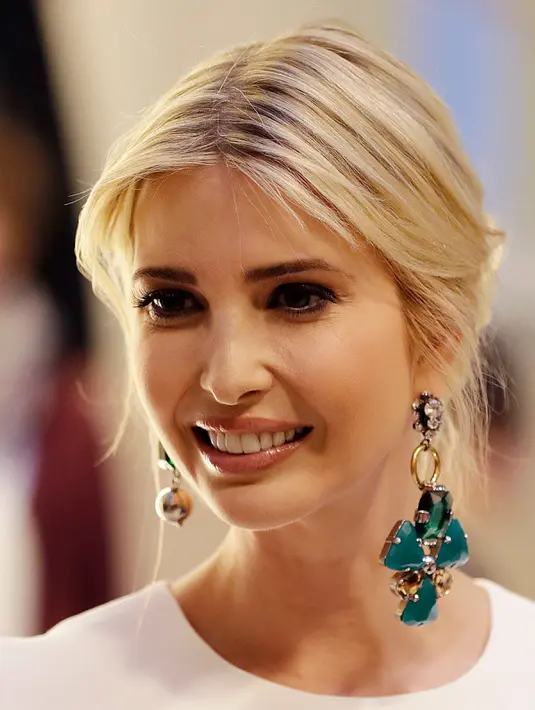 Senyum Ivanka Trump saat menghadiri acara makan malam di Berlin, Jerman (25/4). Ivanka Trump tampil cantik dengan dress berwarna putih. (AP Photo/Michael Sohn, pool)
