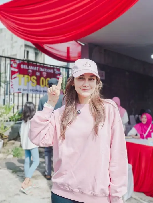 Luna Maya hadir sendiri saat nyoblos, ia memilih tampil serba pink. Mengenakan topi cap Alo dan sweater dipadukan celana denimnya. [@lunamaya]