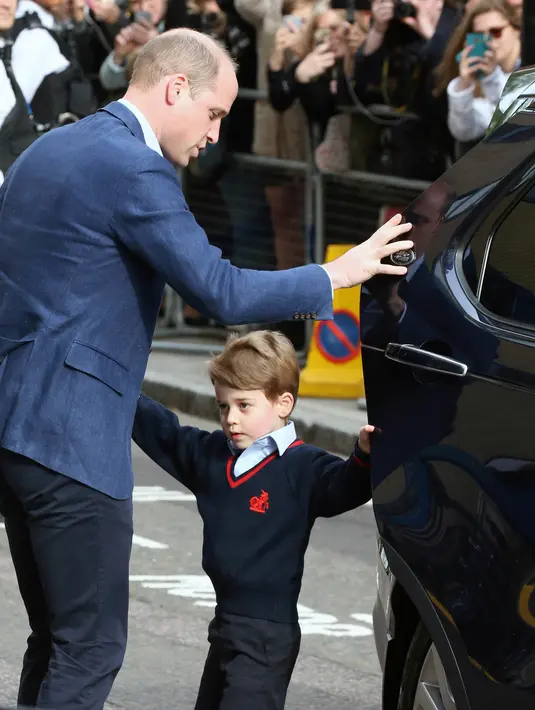 Pangeran William dan kedua anaknya, Pangeran George serta Putri Charlotte mengunjungi tempat Kate Middleton melahirkan di Rumah Sakit St Mary's, London, Senin (23/4). George terlihat malu-malu dalam balutan busana biru seragam sekolahnya. (AP Photo)