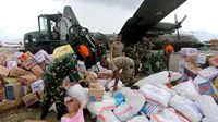 Prajurit TNI dibantu tentara Amerika Serikat mendistribusikan bantuan logistik yang tiba di Bandara Mutiara Sis Al-Jufri, Palu, Sulawesi Tengah, Minggu (7/10). Tentara AS membantu mendistribusikan dari landasan menuju bandara. (Liputan6.com/Fery Pradolo)