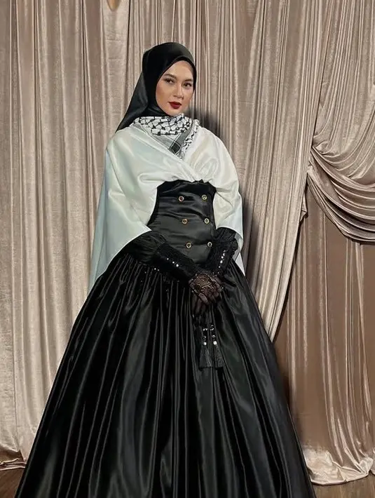 Paula Verhoeven mengenakan koleksi Zaskia Sungkar tampil megah dengan rok panjang hitam dengan siluet korset dipadukan atasan putih dan syal sorban. Dipadukan kerudung hitam dan gloves lace. [@paula_verhoeven]