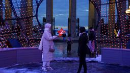 Orang-orang berjalan di dekat pintu masuk Taman Gorky yang dihias untuk perayaan Tahun Baru dan Natal di Moskow, Rusia, Selasa (20/12/2022). Sebelumnya Kyiv sempat memberi seruan pada Rusia untuk menarik pasukannya sebelum Natal, namun ditolak. (AP Photo/Alexander Zemlianichenko)