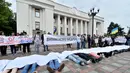 Sejumlah orang menggelar aksi unjuk rasa di depan Parlemen Ukraina di Kiev, Selasa (6/6). Mereka mengingatkan pemerintah bahwa 67 orang Ukraina meninggal setiap hari dari penyakit. (AFP/SERGEI SUPINSKY)