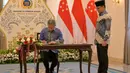 Dalam pernyataannya, Menteri Luar Negeri RI Sugiono menekankan pentingnya penguatan koordinasi antara Indonesia dan Singapura dalam menghadapi dinamika global yang berdampak pada ekonomi dan kawasan. Tampak dalam foto, Menteri Luar Negeri Indonesia Sugiono (kanan) menyaksikan Menteri Luar Negeri Singapura Vivian Balakrishnan mengisi buku tamu selama pertemuan mereka di Gedung Kementerian Luar Negeri, Jakarta pada Selasa 12 Mei 2026. (BAY ISMOYO/AFP)