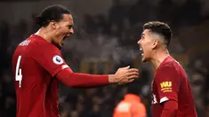 Pemain Liverpool Roberto Firmino (kanan) merayakan golnya ke gawang Wolverhampton Wanderers bersama Virgil van Dijk pada pertandingan Liga Inggris di Molineux Stadium, Wolverhampton, Inggris, Kamis (23/1/2020). Liverpool menang 2-1. (Oli SCARFF/AFP)