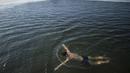 Seorang pria saat berenang di danau Hou Hai yang membbeku di Beijing, China (24/1). (AFP Photo/Nicolas Asfouri)