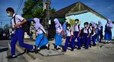 Para siswa tiba di Sekolah Pimarnvit, Provinsi Narathiwat, Thailand, 20 Mei 2022. Thailand melanjutkan sekolah tatap muka secara nasional untuk tahun ajaran baru setelah bertahun-tahun terganggu karena pandemi COVID-19. (Madaree TOHLALA/AFP)