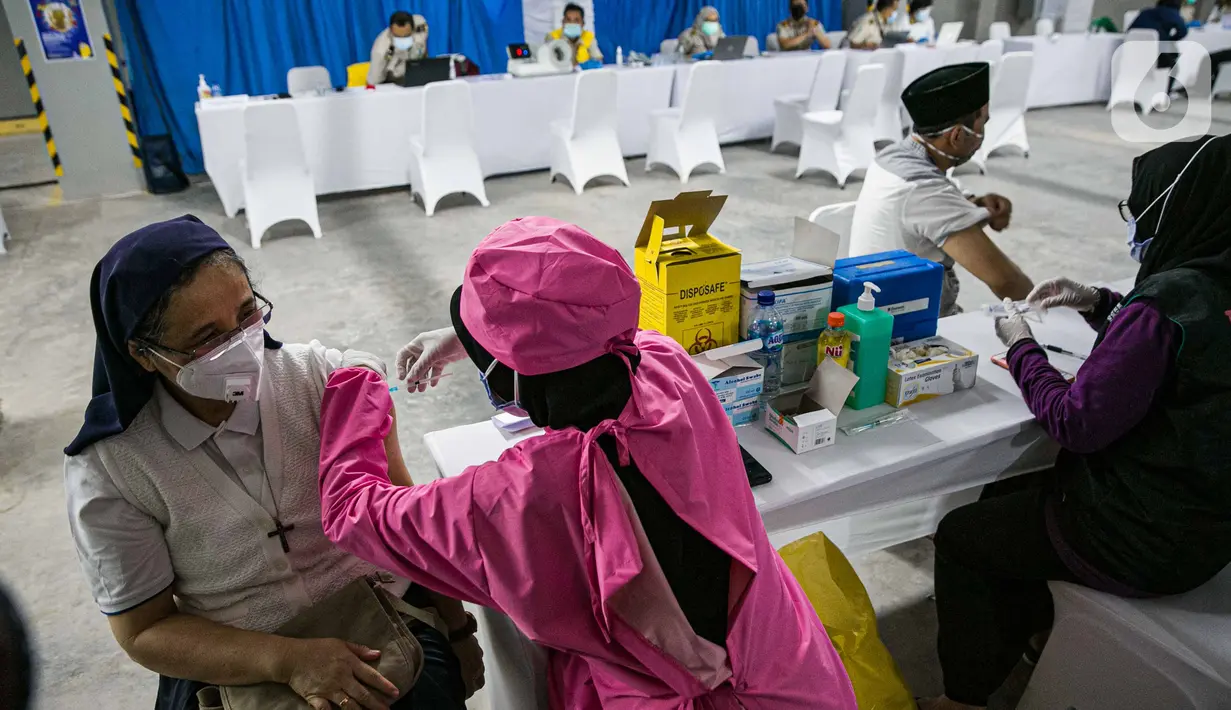 Petugas kesehatan menyuntikan vaksin COVID-19 kepada seorang pemuka agama di Mesjid Istiqlal, Jakarta, Selasa (23/2/2021). Pemuka agama yang mengikuti vaksinasi ini mencapai ribuan orang. (Liputan6.com/Faizal Fanani)