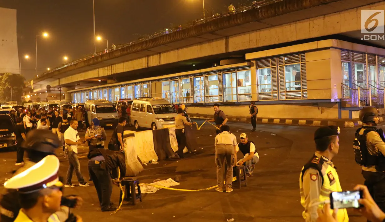 Petugas memasang garis pembatas di lokasi terjadinya ledakan di sekitar Terminal Kampung Melayu, Jakarta, Rabu (24/5). Polisi belum bisa memastikan apakah tiga korban jiwa itu merupakan anggota polisi atau warga sipil. (Liputan6.com/Angga Yuniar)