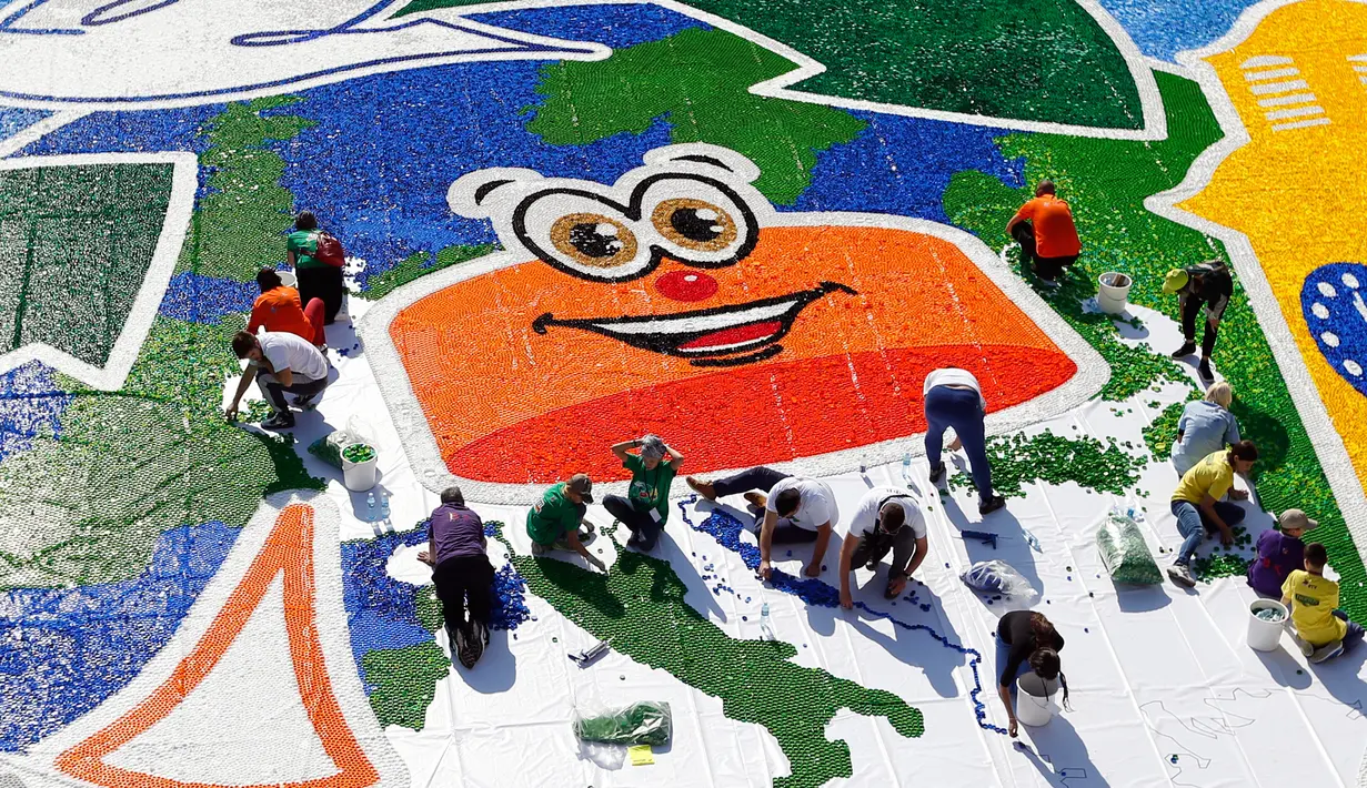 Sejumlah relawan membuat mosaik raksasa dari 100 ton limbah tutup botol dalam acara "A Bottle Cap for Handicap" di kota Novi Sad, Serbia, Sabtu (30/9). Pembuatan mosaik berukuran 621 meter persegi tersebut melibatkan 300 relawan. (AP/Darko Vojinovic)