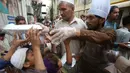 Relawan mendistribusikan kotak makanan untuk orang-orang yang berbuka puasa bersama selama bulan suci Ramadan di Peshawar, Pakistan, Senin (11/5/2020). Warga berbuka puasa bersama setelah pemerintah melonggarkan lockdown terkait pandemi virus corona COVID-19. (AP Photo/ Muhammad Sajjad)