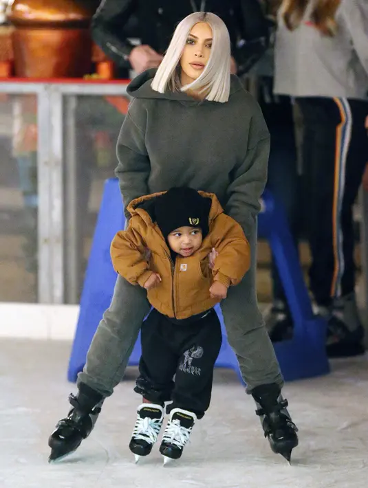 Dengan sigap, Kim Kardashian pun mengangkat Saint saat adik dari North tersebut mulai terlihat tak seimbang dan hampir jatuh. (Brewer - Prahl - Splash News - HollywoodLife)