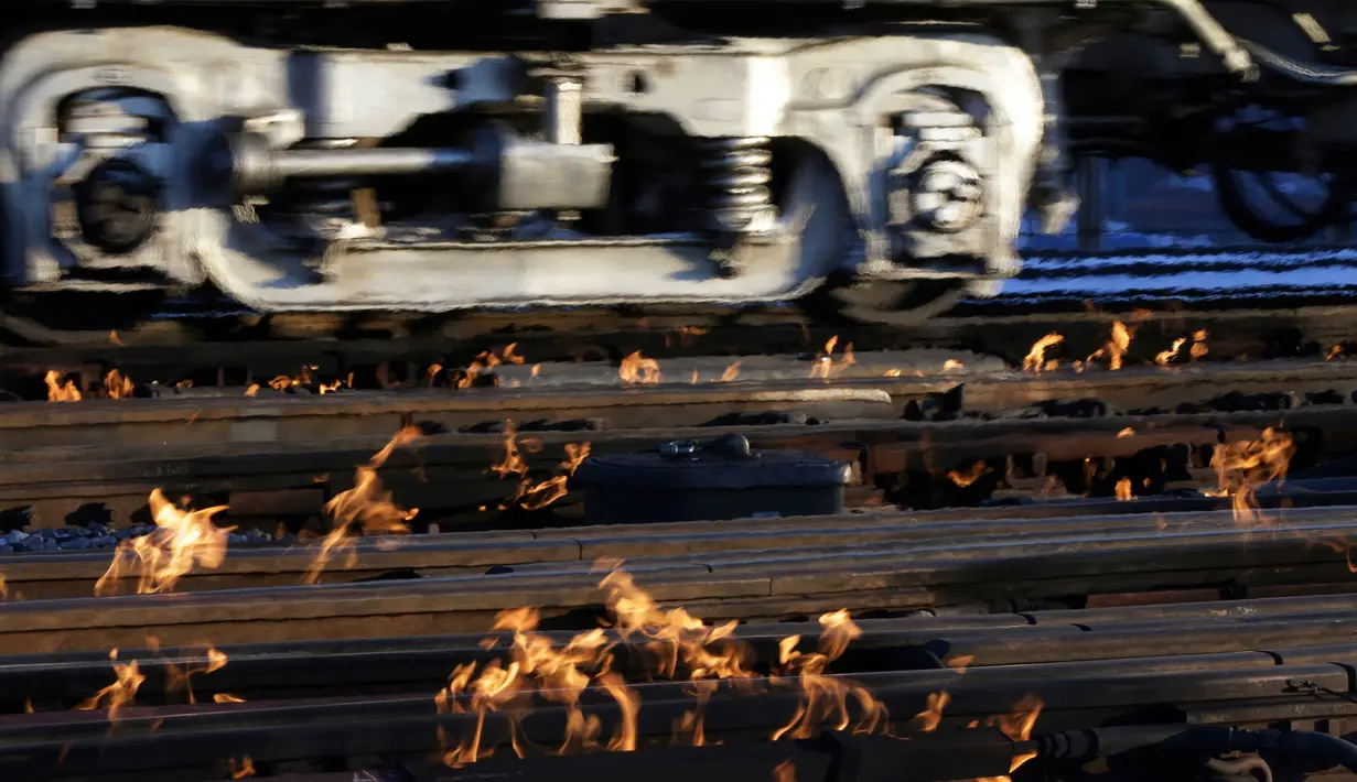 Sistem pemanas berbahan bakar gas menghangatkan lintasan rel kereta di dekat stasiun Metra Western Avenue, Chicago, 29 Januari 2019. Para petugas berupaya membuat kereta komuter tetap beroperasi di tengah suhu udara yang sangat dingin. (AP/Kiichiro Sato)
