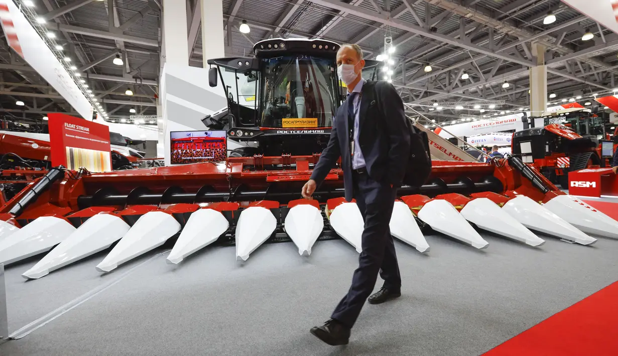 Seorang pengunjung yang mengenakan masker untuk melindungi diri dari COVID-19 berjalan melewati mesin pertanian yang ditampilkan dalam pameran pertanian internasional Agrosalon di Moskow, Rusia, 7 Oktober 2020. Pameran tersebut digelar setiap dua tahun di Moskow. (Xinhua/Alexander Zemlianichenko Jr)