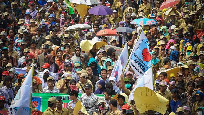 Ribuan pegawai honorer menggelar aksi longmarch dari patung kuda menuju Istana Negara, Jakarta, (15/10/14). (Liputan6.com/Faizal Fanani)