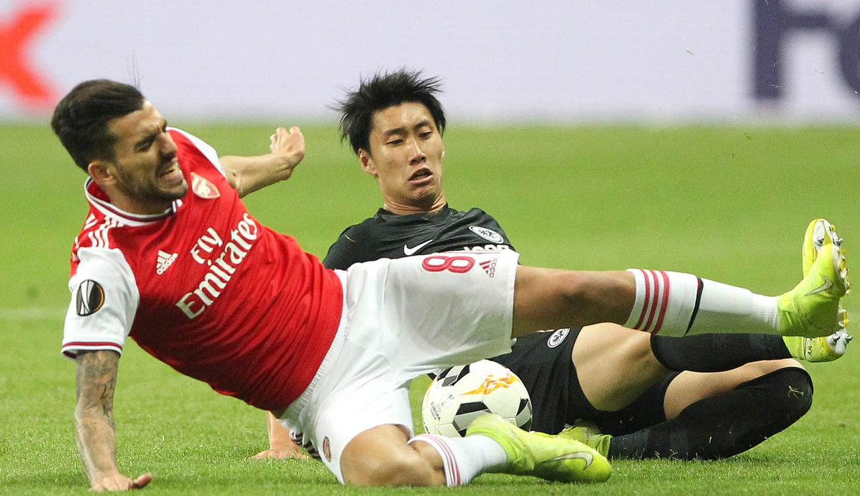 Gelandang Arsenal, Dani Ceballos, dijatuhkan gelandang Eintracht Frankfurt, Daichi Kamada, pada laga Europa League di Frankfurt, Kamis (19/9). Frankfurt kalah 0-3 dari Arsenal. (AFP/Daniel Roland)