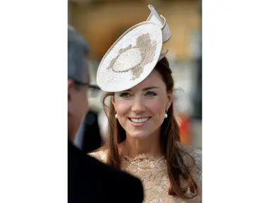 Duchess of Cambridge, Kate Middleton tersenyum saat menemui tamu undangan yang hadir di Istana Buckingham, London, (10/6). (REUTERS/John Stillwell)