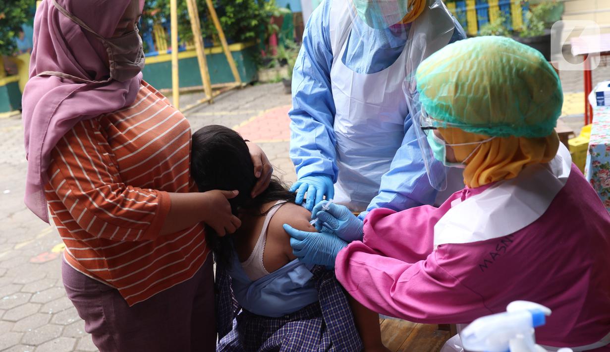Petugas kesehatan menyuntikkan imunisasi kepaad siswa Sekolah Dasar di SDN Tangerang 1, Kota Tangerang, Kamis (19/11/2020). Pemberian imunisasi untuk memberikan perlindungan kepada anak-anak usia SD serta meningkat daya tahan tubuh serta mencegah berbagai penyakit. (Liputan6.com/Angga Yuniar)