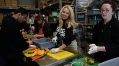 Aktris AS, Pamela Anderson membantu menyiapkan makanan untuk imigran di sebuah kamp di Calais, Prancis, 3 Mei 2017. Model panas era 90-an itu membantu kegiatan relawan di kamp tersebut, seperti memasak dan memilah selimut. (FRANCOIS LO PRESTI/AFP)