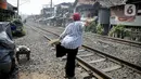 Warga berolah raga ringan sambil berjemur di bantaran rel di kawasan pemukiman padat Pejompongan, Jakarta, Selasa (6/7/2021). Berjemur diri di bawah matahari di antara pukul 08.00-11.00 WIB merupakan salah satu upaya menjaga kesehatan selama wabah virus COVID-19. (Liputan6.com/Faizal Fanani)