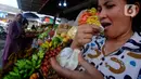Warga mencicipi buah salju di Pasar Candi Kuning, Bedugul, Bali, Senin (24/04/2023). Buah ini sempat viral di media sosial beberapa waktu lalu. (merdeka.com/Arie Basuki)
