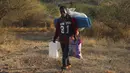 Pengungsi Ethiopia berjalan di wilayah Qadarif, Sudan, Rabu (18/11/2020). Badan Pengungsi PBB mengatakan konflik yang berkembang di Ethiopia telah mengakibatkan ribuan orang melarikan diri dari wilayah Tigray ke Sudan. (AP Photo/Marwan Ali)