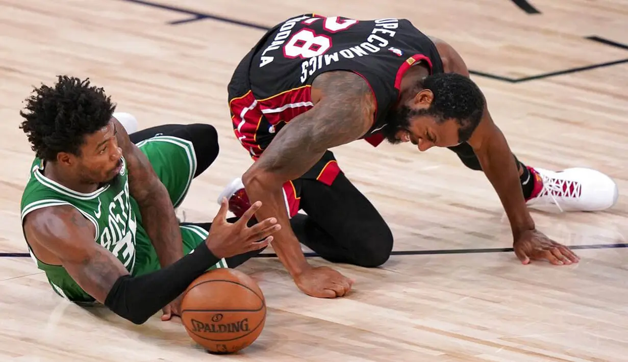 Pebasket Boston Celtics, Marcus Smart, berebut bola dengan pebasket Miami Heat, Andre Iguodala, pada gim keempat final NBA Wilayah Timur di AdventHealth Arena, Kamis (24/9/2020). Miami Heat menang dengan skor 109-112. (AP/Mark J. Terrill)