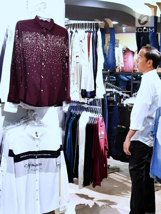 Presiden Jokowi melihat pakaian yang dijual di Palembang Square, Palembang (21/1). Sambil berjalan menuju sebuah gerai yang berada di lantai dasar mal, Presiden Jokowi bersalaman dan berswafoto dengan warga. (Liputan6.com/Pool/Biro Setpres)