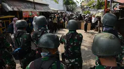 Personel TNI berdiskusi dan rekonsiliasi dengan warga untuk mencegah kerusuhan susulan di Jalan KS Tubun, Petamburan, Jakarta, Rabu (22/5/2019). Aparat keamanan berhasil menghalau massa aksi 22 Mei yang sebelumnya berkumpul di kawasan tersebut. (merdeka.com/Imam Buhori)