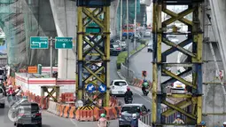 Kendaraan melintas di bawah proyek pembangunan jembatan layang di Jalan Kapten P. Tendean, Jakarta Selatan, (14/7). Aktivitas pembangunan jalan layang busway Tendean-Ciledug masih belum berjalan penuh pasca libur Lebaran. (Liputan6.com/Yoppy Renato)