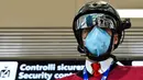 Petugas memperlihatkan termoscanner portabel "Smart-Helmet" untuk memeriksa suhu penumpang dan sesama staf di terminal keberangkatan bandara Fiumicino Roma, Italia pada 5 Mei 2020. Hal ini dilakukan guna menyaring orang yang memiliki gejala infeksi virus corona. (ANDREAS SOLARO/AFP)