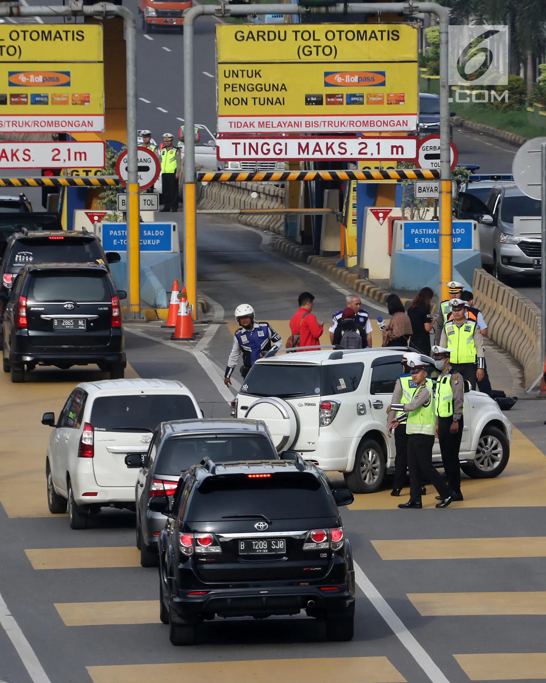 Petugas mengarahkan kendaraan berplat genap berputar balik di Gerbang Tol Bekasi Barat 1, Bekasi, Jawa Barat, Selasa (13/3). Hari kedua penerapan ganjil genap, masih banyak kendaraan berputar balik di gerbang tol tersebut. (Liputan6.com/Arya Manggala)