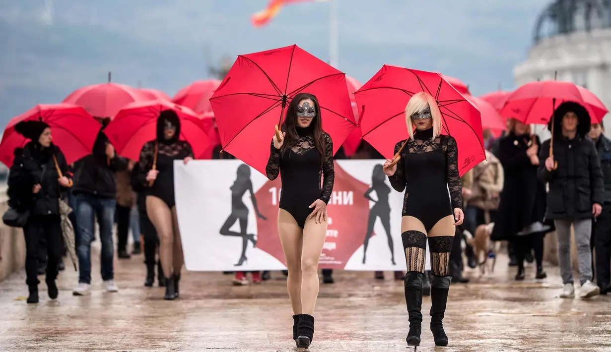 Sejumlah wanita pekerja seks menggenakan busana hitam dan topeng serta membawa payung merah berunjuk rasa di Skopje (17/12). Para pekerja seks ini memprotes kekerasan yang mereka alami, dan hukuman untuk klien prostitusi. (AFP Photo/Robert Atanasovski)