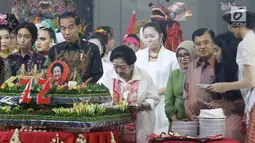 Ketum PDIP Megawati Soekarnoputri memotong tumpeng pada HUT ke-72 didampingi Presiden Joko Widodo serta Wapres Jusuf Kalla di Grand Sahid Jakarta, Rabu (23/1). Sejumlah menteri Kabinet Gotong Royong hadir dalam acara tersebut. (Liputan6.com/Angga Yuniar)