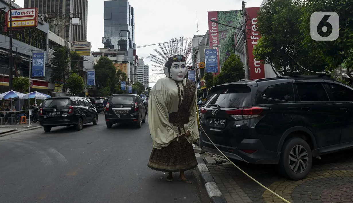 Pengamen ondel-ondel berkeliling di kawasan Sabang, Jakarta, Selasa (11/2/2020). DPRD DKI Jakarta berencana merevisi Perda Nomor 4 Tahun 2015 tentang Pelestarian Kebudayaan Betawi. Revisi ini bertujuan untuk melarang penggunaan ondel-ondel sebagai alat mengamen. (merdeka.com/Imam Buhori)