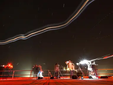 Foto dengan teknik long eksposur menunjukkan para fotografer bekerja dari atap gedung perakitan kendaraan saat roket SpaceX Falcon 9 dengan pesawat ruang angkasa Crew Dragon milik perusahaan tersebut mengosongkan bahan bakar sebelum peluncuran yang telah digosok dari pad 39A untuk misi Crew-6 di Kennedy Space Center NASA di Cape Canaveral, Florida, pada tanggal 27 Februari 2023. (CHANDAN KHANNA/AFP)